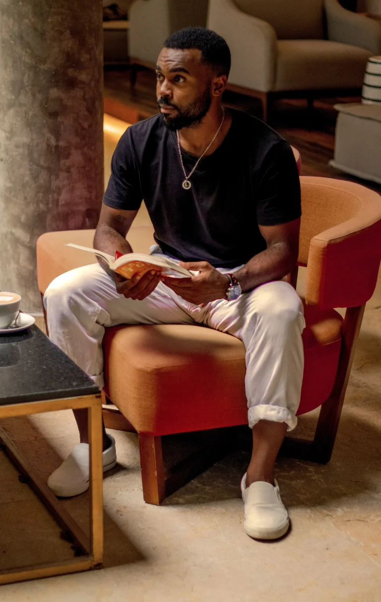 Hombre leyendo un libro sentado en sillón lounge - sesión de personal branding masculino